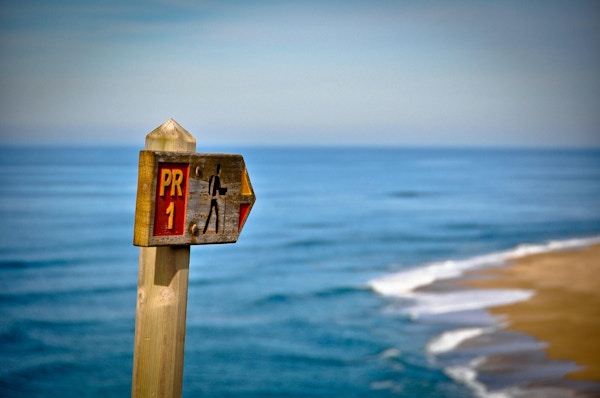 Trail Sign som pekar på stranden.