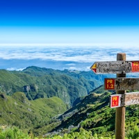 Skylt på toppen av Madeira Island som visar vägen till Pico Ruivo, Ilha och Achada do Teixeira
