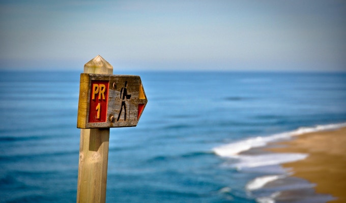 Trail Sign som pekar på stranden.