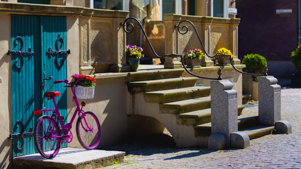 Rosa cykel som vilar i sommarsolen