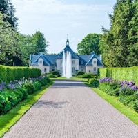 Vacker grusgång omgiven av häckar och blommoar, gångnen leder fram till en sprutande fontän framför Villa Albelin, Norrvikens Trädgårdar, Bjärehalvön, Skåne, Sverige
