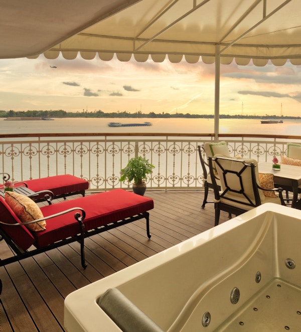 Hoppa över terrassen med jacuzzi, solstolar, sittplatser och Mekong River i bakgrunden. Foto.