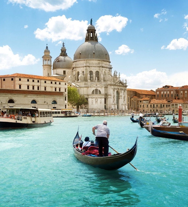 Sikt över kanalen i Venedig. Gondoler och färjor transporterar passagerare.