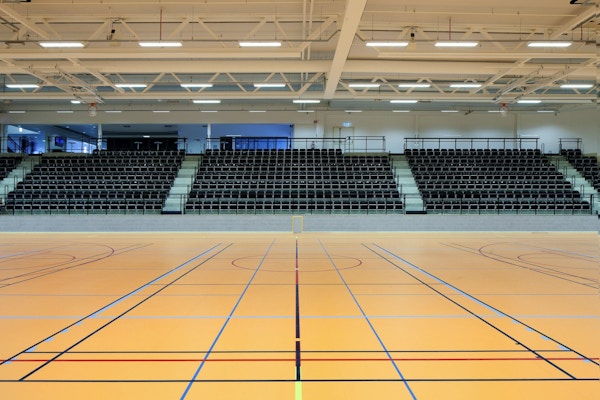 Två idrottshallar med skiljevägg och läktare, Prioritet Serneke Arena