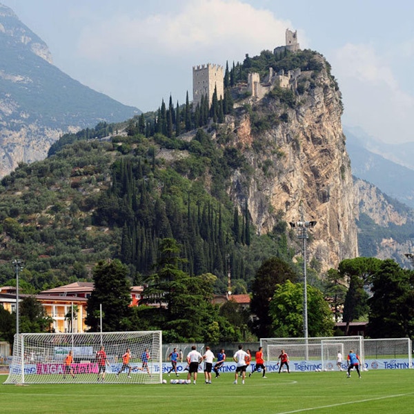 Proffslag tränar på konstgräsplan med berg i bakgrunden, Garda, Italien