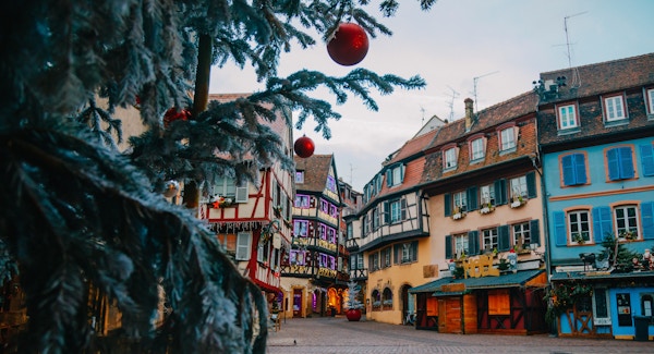 Gamla stan dekorerar magiskt som en saga i Noel festlig säsong med detalj av julgran med röda boll utsmyckade tidigt på morgonen i Colmar, Alsace, Frankrike.