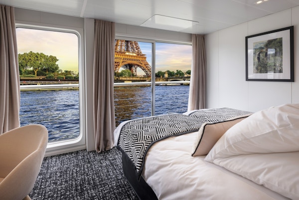 Interiör av en stuga på ett flodkryssningsfartyg med Eiffeltornet utanför.