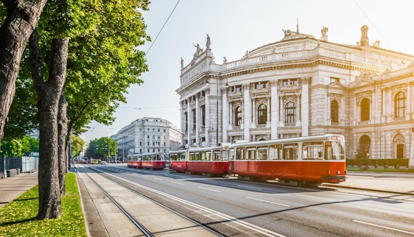 Famous Wiener Ringstrasse with historic Burgtheater (Imperial Court Theatre) and traditional red electric tram at sunrise with retro vintage Instagram style filter effect in Vienna, Austria.