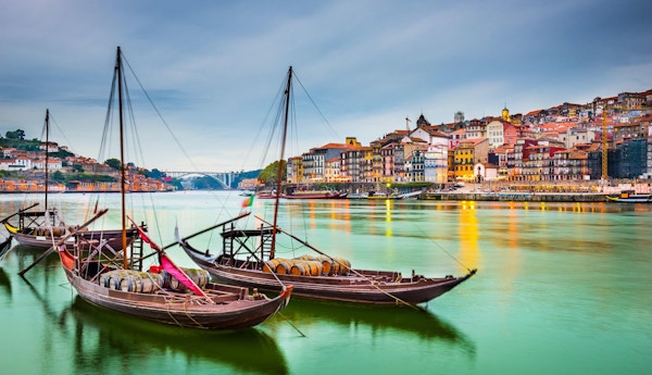 Porto, Portugal old town cityscape on the Douro River with traditional Rabelo boats.