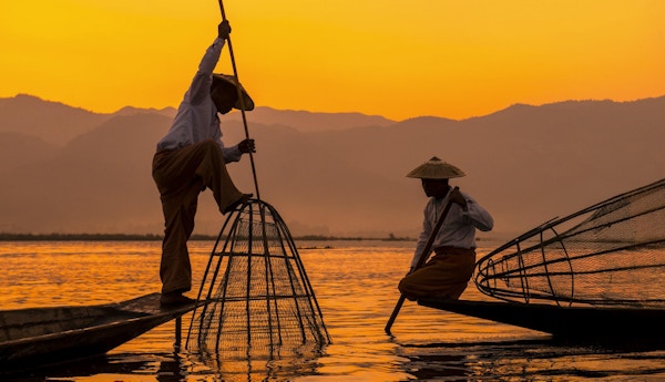 Två fiskare i härlig solnedgång vid sjön Inle, Myanmar