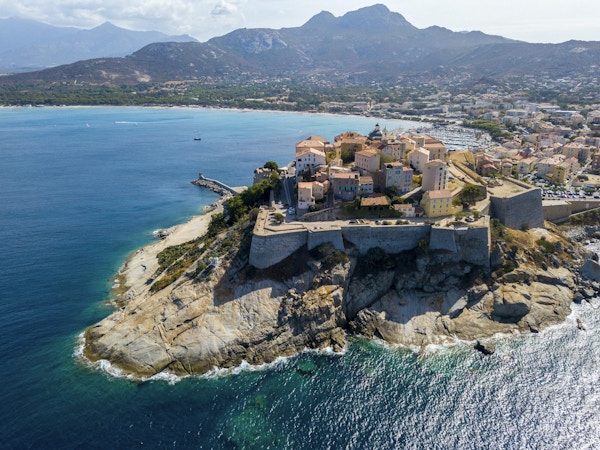 Flyg- sikt av den Calvi staden, Korsika, Frankrike. Väggar i staden, klippa med utsikt över havet