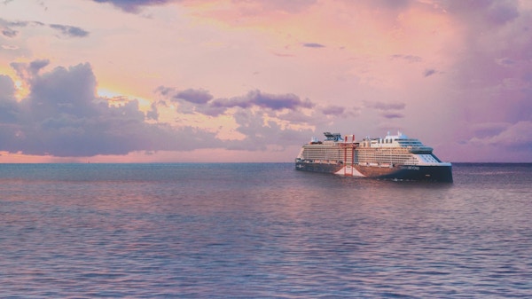 Kryssningsfartyg till havs med rosa solnedgång.