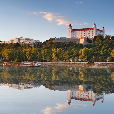 Bratislava slott med reflexion i floden Donau