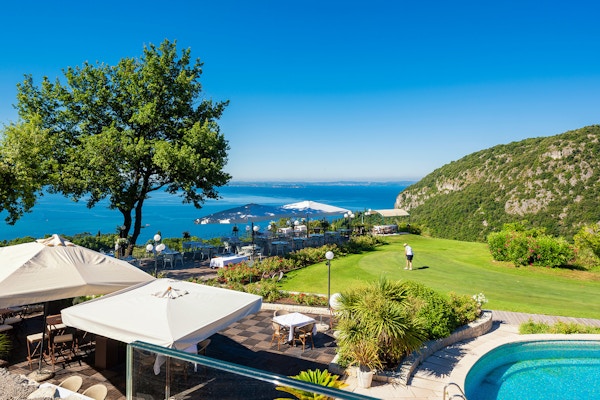 Hotellets pool och terrass med golf green och utsikt över Gardasjön, Golf Hotel Ca' Degli Ulivi, Garda, Italien
