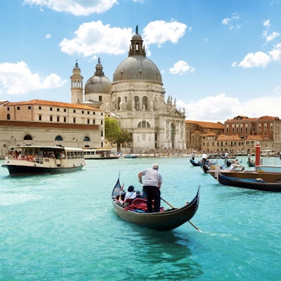 Sikt över kanalen i Venedig. Gondoler och färjor transporterar passagerare.