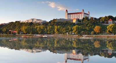 Bratislava slott med reflexion i floden Donau