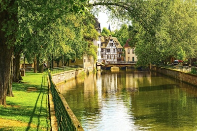 Strasbourg, vattenkanal i området Petite France. Korsvirkeshus och träd i Grand Ile. Alsace, Frankrike. Unesco-webbplats.
