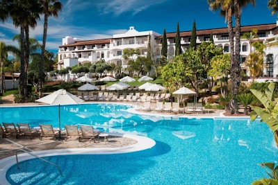 Pool med oregelbunden form, solstolar, parasoller, palmer, grönska, blå himmel och sol, The Westin La Quinta Golf Resort & Spa, Marbella, Spain