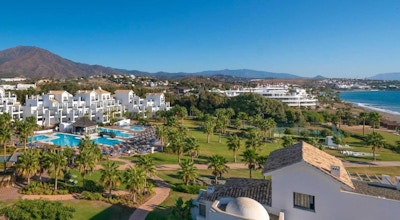 Hotellområdet med palmer, pool och strand, i bakgrunden syns Estepona centrum, Estepona Hotel & Spa Resort, Estepona, Spanien