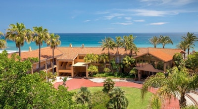 Hotellbyggnaden med palmer och havet i bakgrunden, blå himmel, Hotel Guadalmina Spa and Golf Resort, Marbella, Spanien