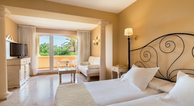 Ljust rum med dubbelsäng, soffa, TV och balkong, Hotel Guadalmina Spa and Golf Resort, Marbella, Spanien