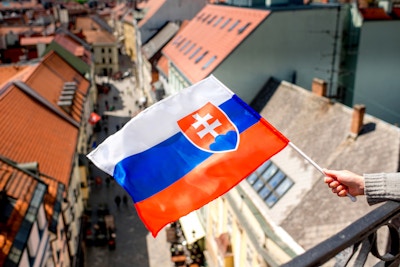 Slovakisk flagga på den gamla stadsbakgrunden i Bratislava, huvudstaden i Slovakien