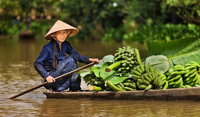 Vietnamesisk kvinna som roar en båt på Mekong River Delta, Vietnam