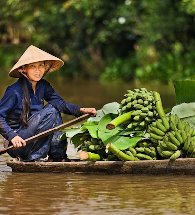 Vietnamesisk kvinna som roar en båt på Mekong River Delta, Vietnam