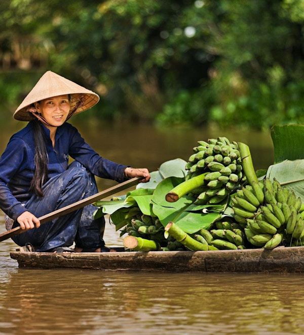 Vietnamesisk kvinna som roar en båt på Mekong River Delta, Vietnam