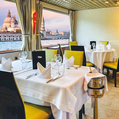 Restaurangbord med vy över Venedig utanför fartygsfönstret