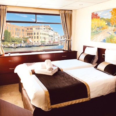 Säng med vy över Venedig utanför fartygsfönstret