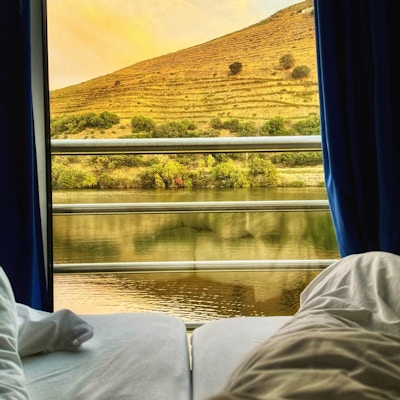 Fotändan av sängen med floden Douro utanför fönstret